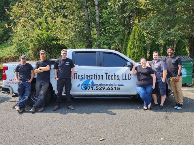 A group of people standing in front of a truck.