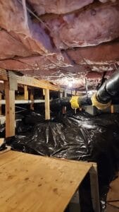 A basement that has been insulated with black tarps.
